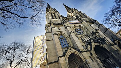 Kirche mit Doppelturmfassade, Fahne mit "St. Maria als ..."