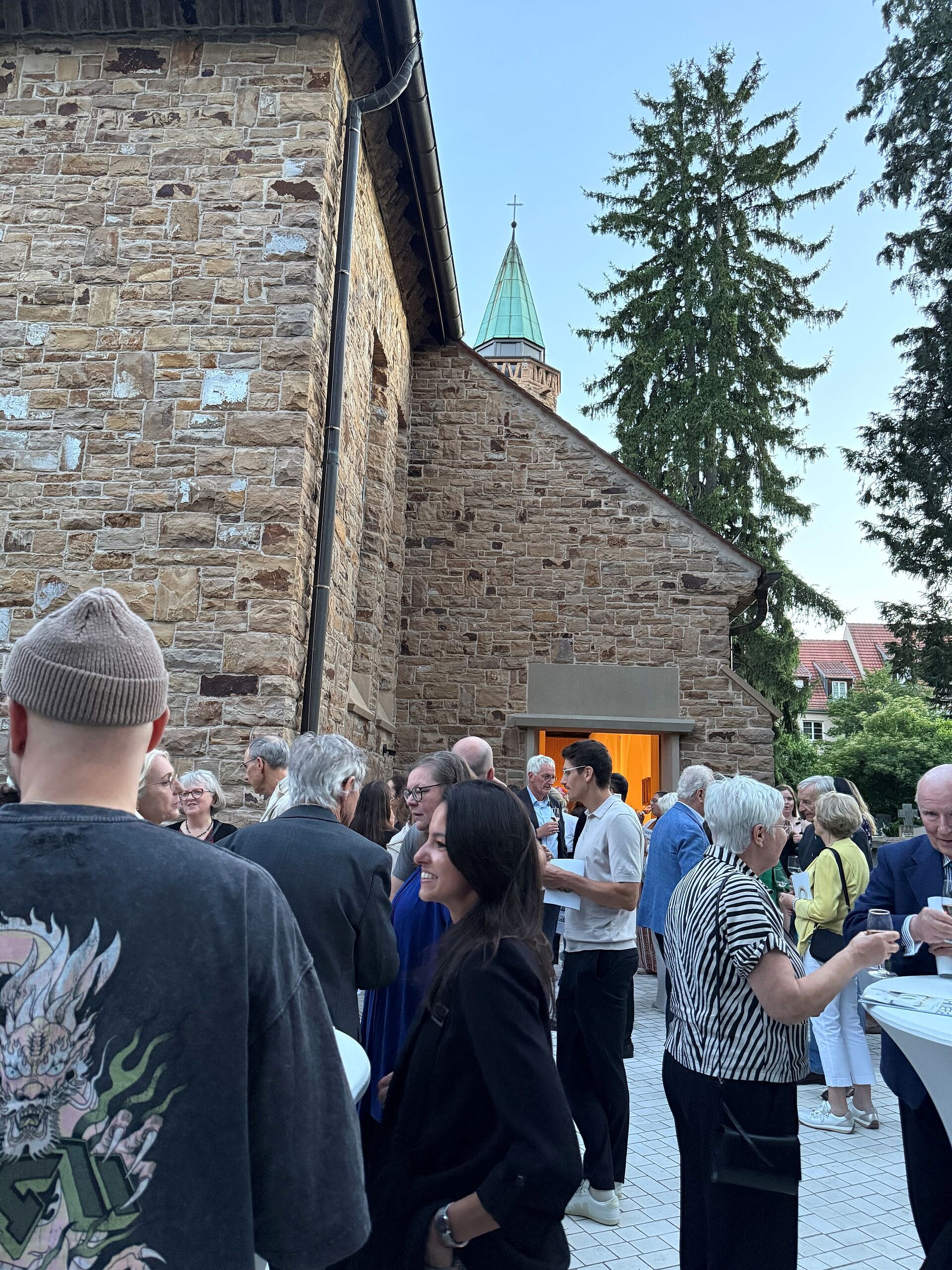 Menschen im Gespräch im Garten hinter der Kirche Mariä Himmelfahrt in Degerloch