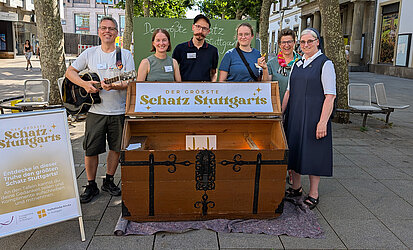 Team-Foto vor einer großen Holztruhe mit der Aufschrift "Der größte Schatz Stuttgarts"