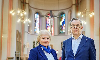 Pfarrer Werner Laub und die Gewählte Vorsitzende vor dem Chorraum der Kirche St. Elisabeth