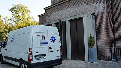 Ein Transporter der Schwäbischen Tafel Stuttgart steht vor dem Eingang der katholischen Kirche St. Georg in der Heilbronner Straße in Stuttgart.
