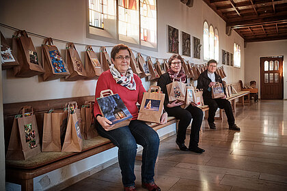 Angelika Maderthaner, Regina Arnold und Pfarrer Andreas Gälle haben die Adventstüten in die Kirche St. Johannes gebracht.