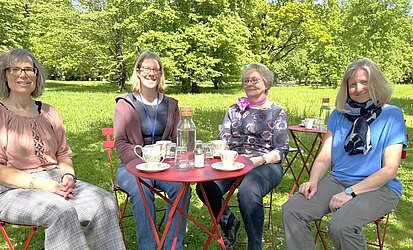 Frauen, die beim Café Kränzchen auf dem Hauptfriedhof mitwirken haben an einem der Tische Platz genommen